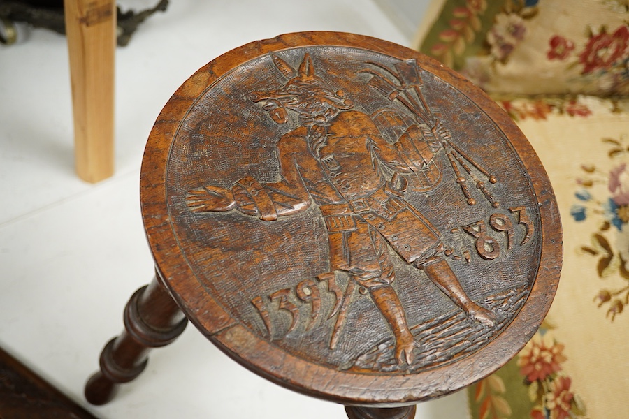 A Black Forest carved book-rack and a commemorative carved oak stool, for the Winchester college emblem, stool 39cm high